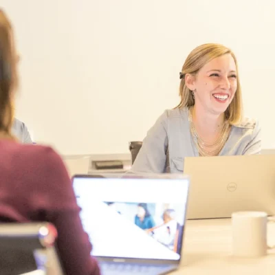 Happy employee at Apex Leaders in a discussion, showcasing a thriving workplace for those in private equity careers.