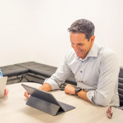 Smiling professional at private equity consulting services provider, Apex Leaders, collaborating on a project, showcasing their personalized advisor services.