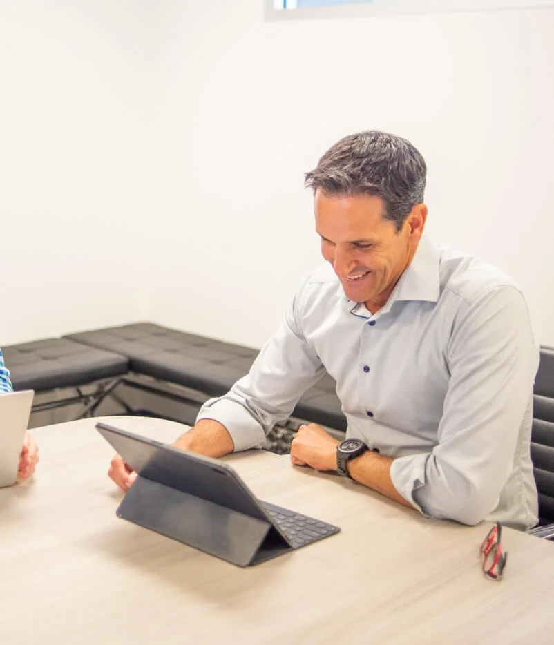 Smiling professional at private equity consulting services provider, Apex Leaders, collaborating on a project, showcasing their personalized advisor services.