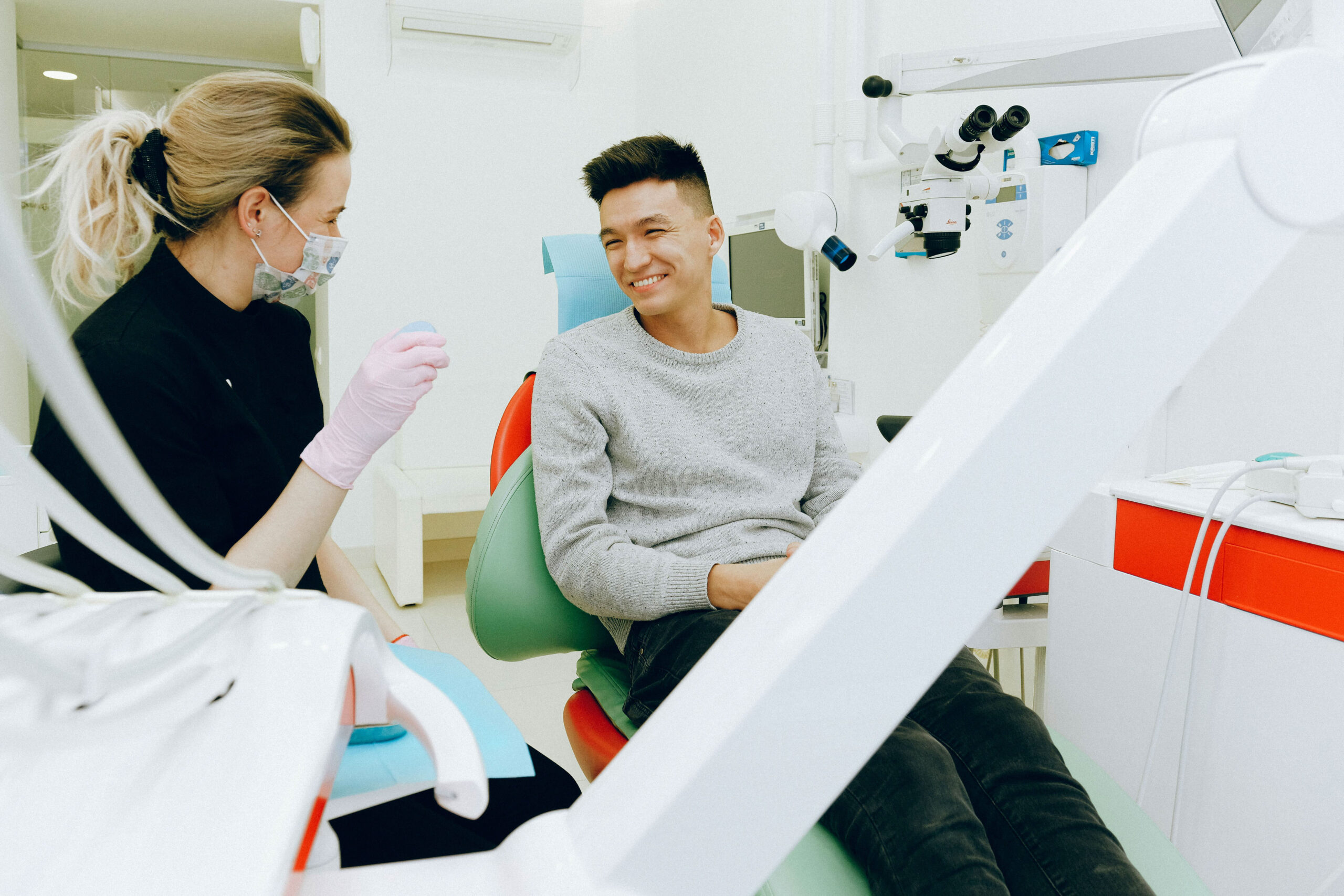 A young person smiles after going to a new dentists office, which scaled up after a successful private equity investment thesis.