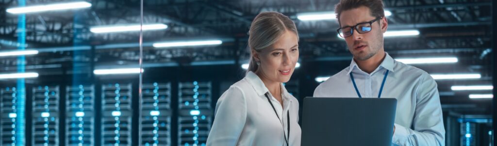 Two professionals conducting technology due diligence in a data center, reviewing investment opportunities in cloud IT services.