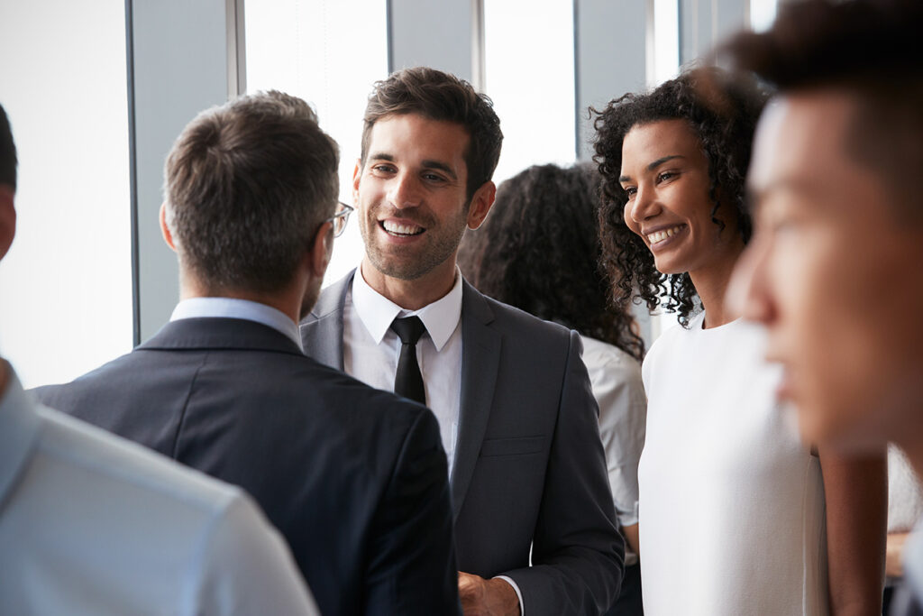 two guys talking in a crowded room