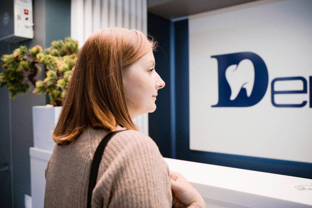 A woman waits at a specialty dental clinic counter, an emerging dental industry trend.