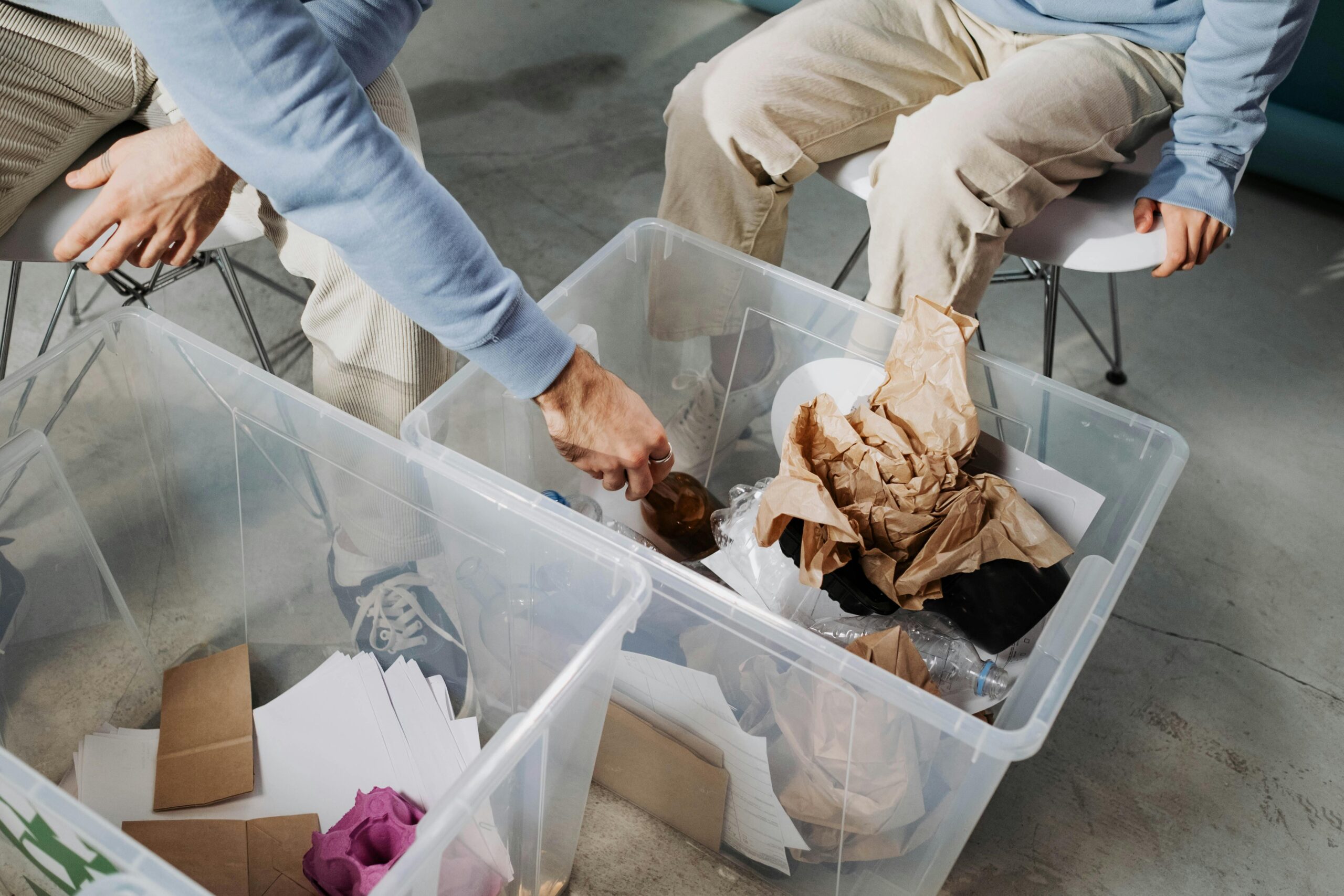 Two people are shown organizing their recycling for the waste industry.