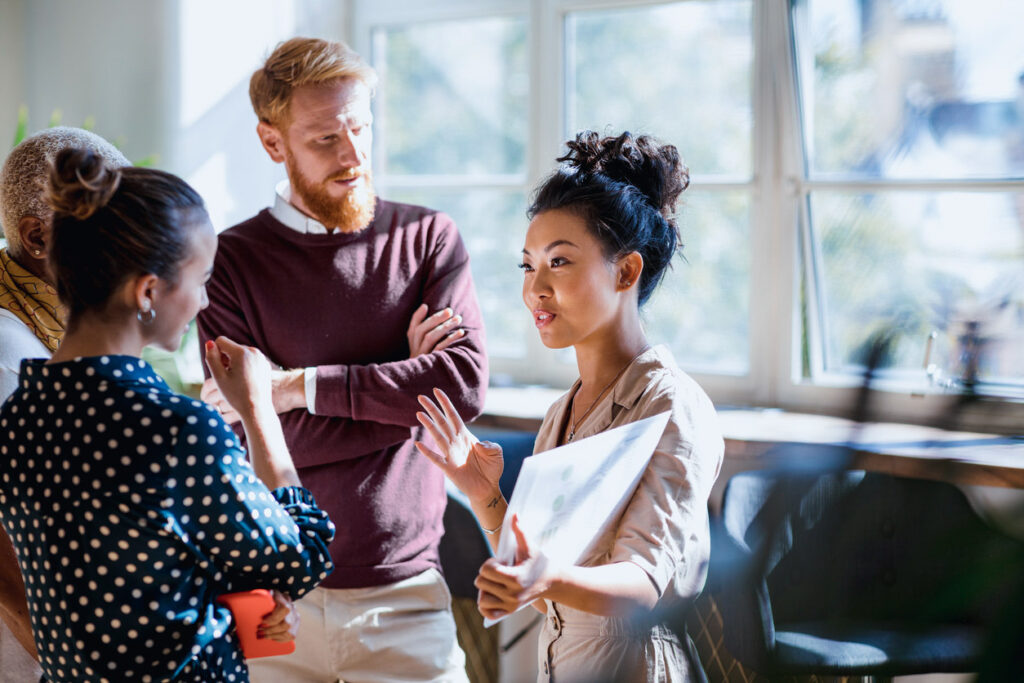 A group of experts from expert network companies stand and talk in a small group.