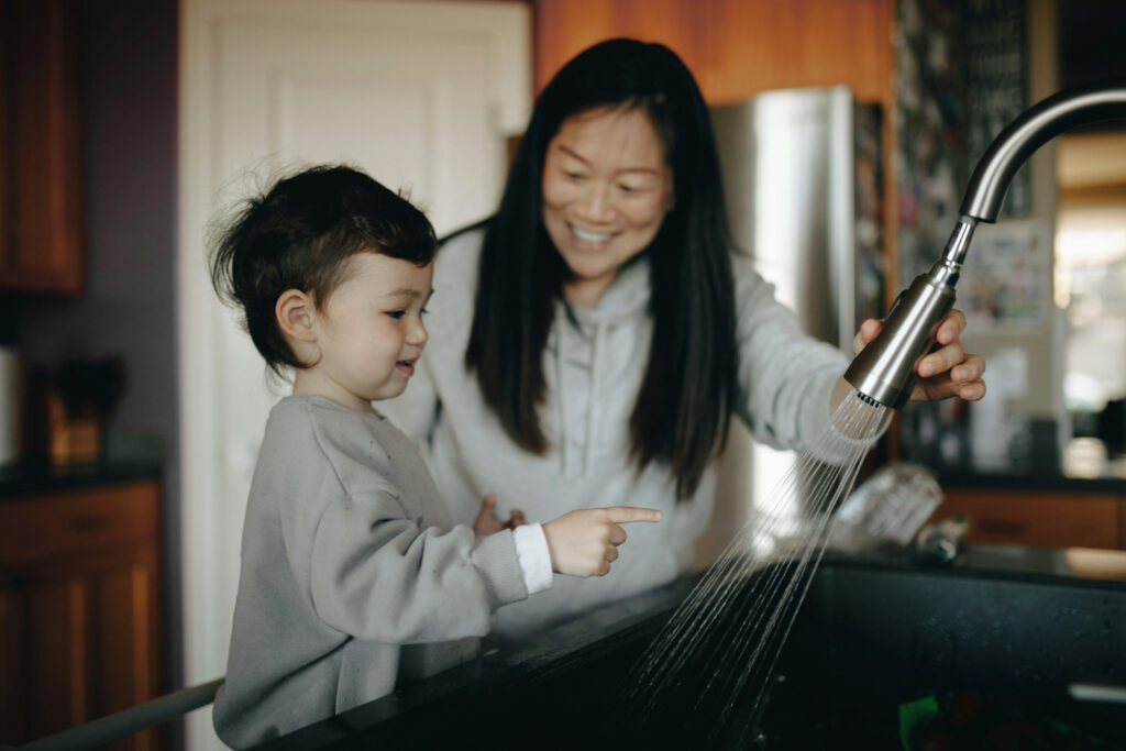 A mother and child play in the sink, powered by the pumps industry.