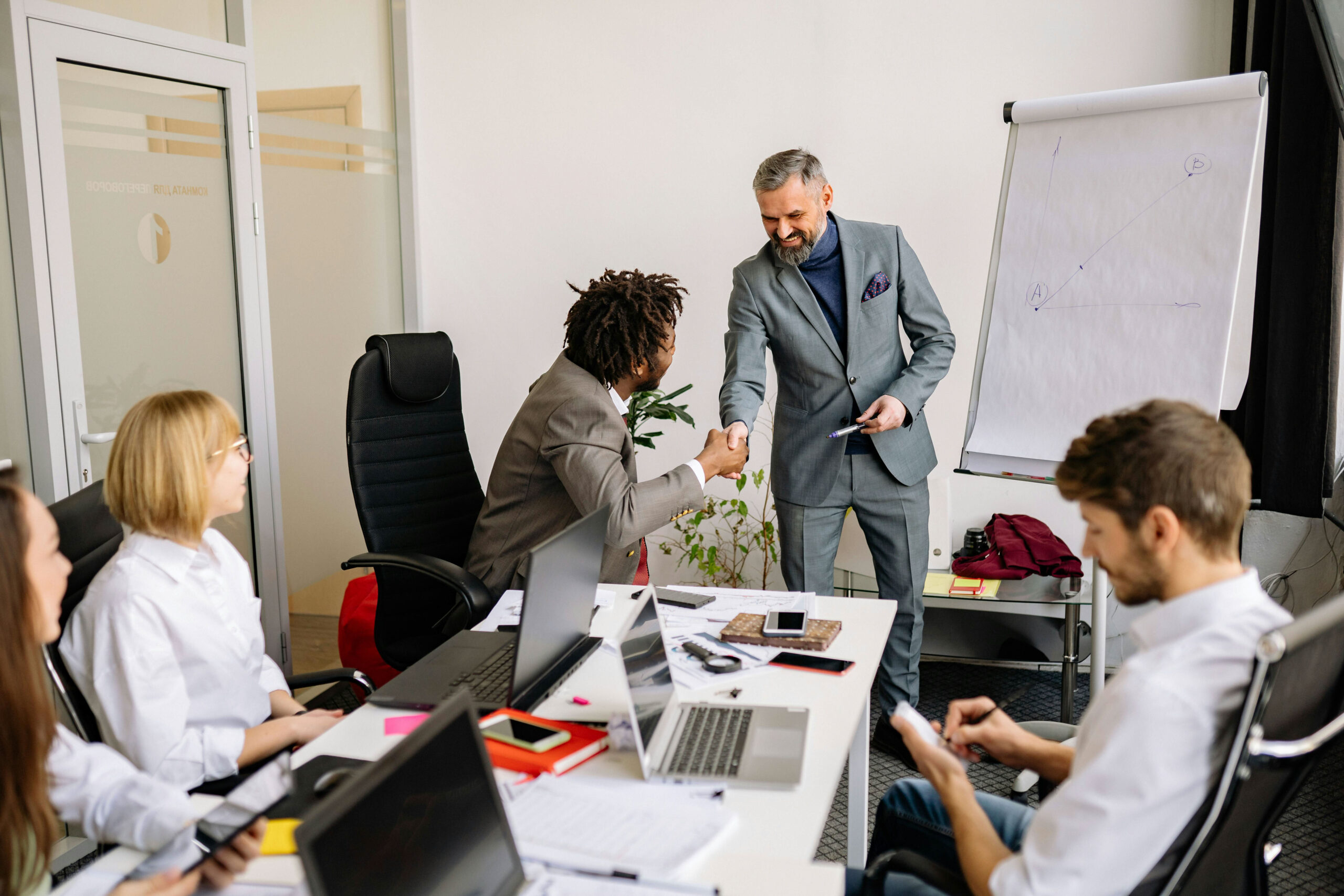 An advisor from a private equity due diligence consulting firm addresses a small team in their business office.
