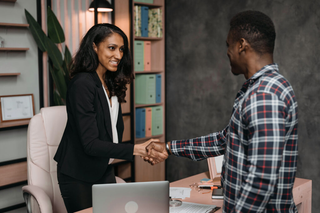 PE consulting professional shaking hands with a client, symbolizing trust and partnership in private equity advisory services.