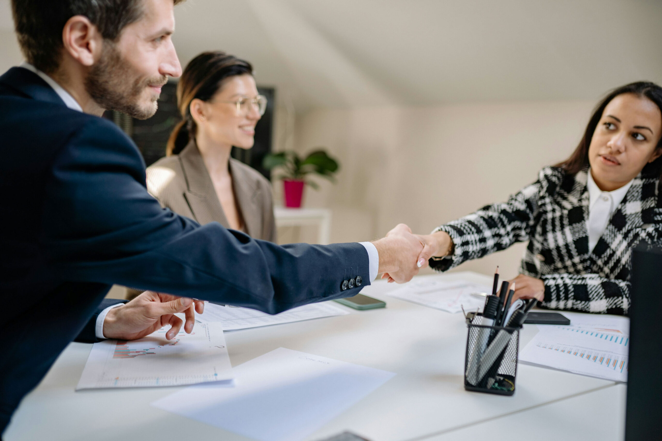 A new team gets acquainted with a handshake around an office table.