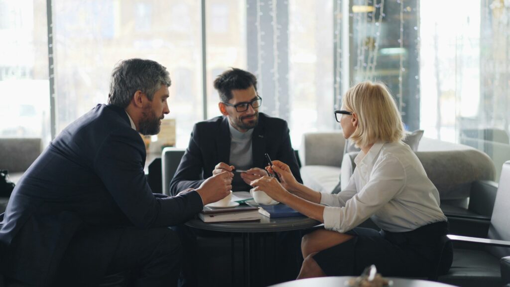 Private equity colleagues around table discussing due diligence insights from expert network.