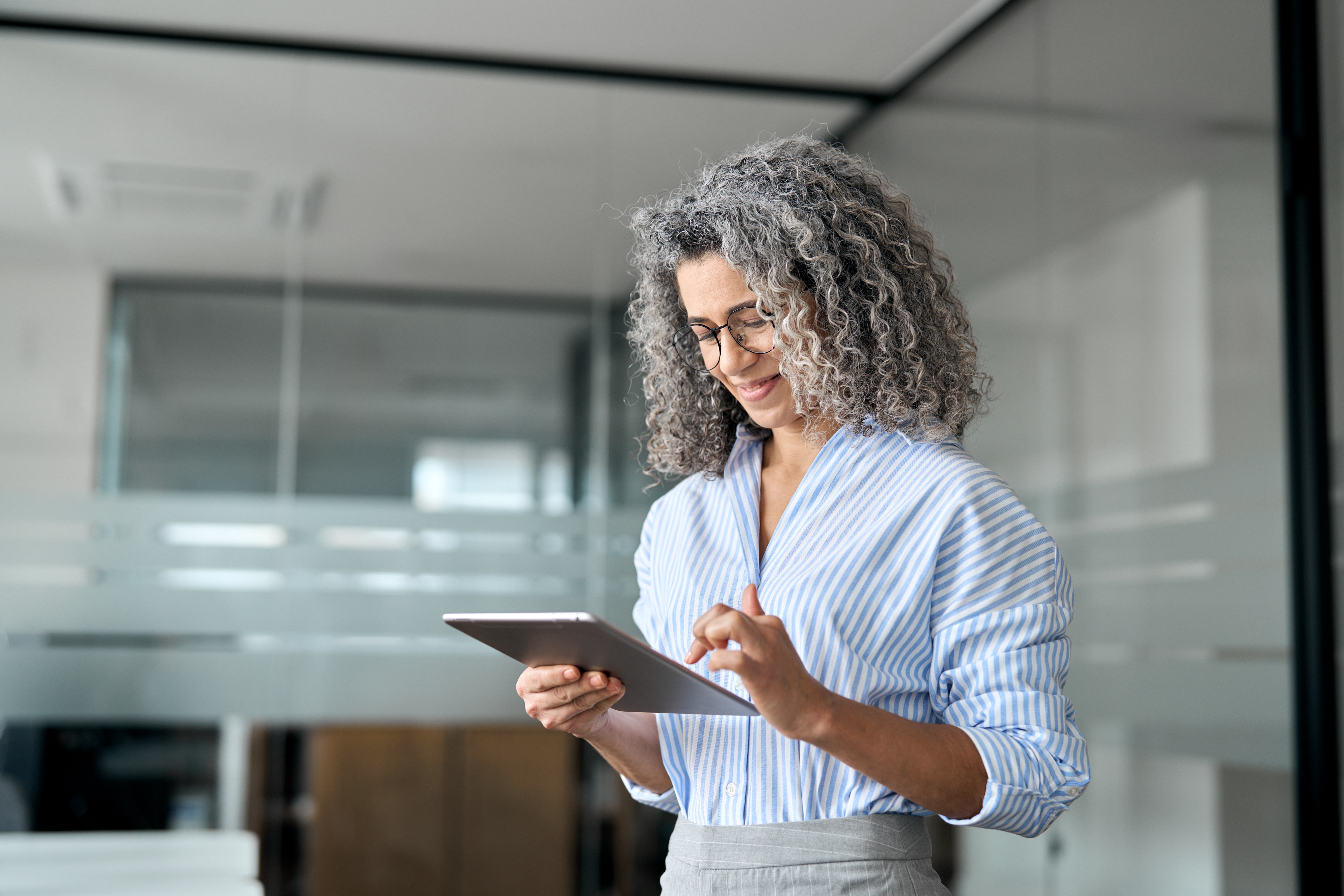 Smiling woman using a tablet for private equity due diligence in the HVAC sector