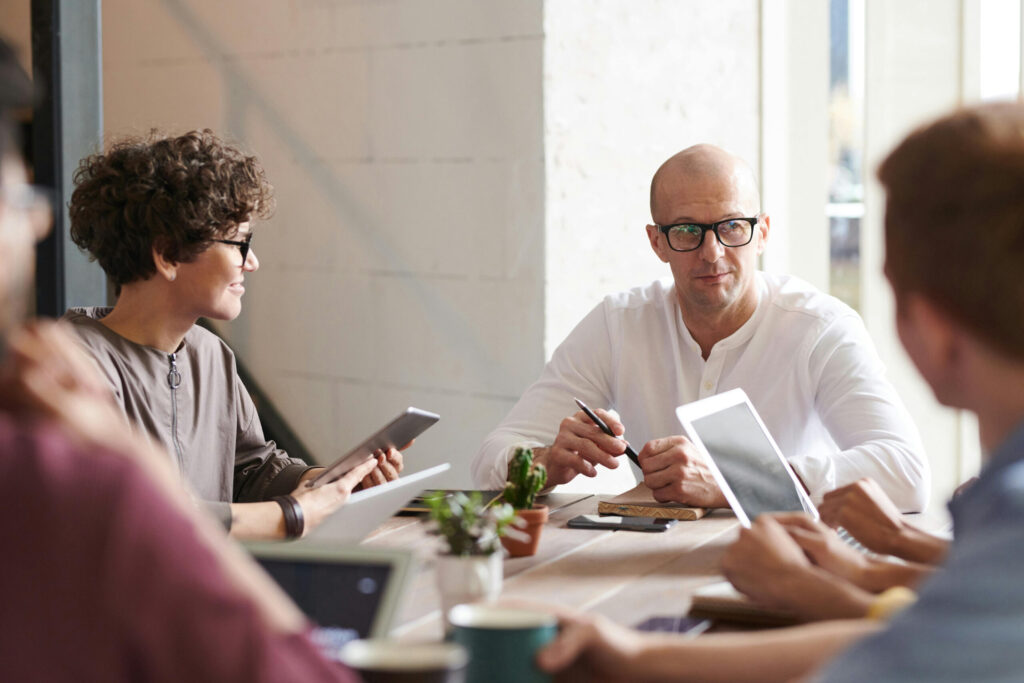 Private equity executives debriefing at conference table after a expert network call.
