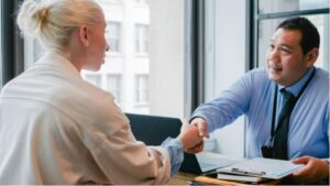 a man and woman shaking hands over a desk